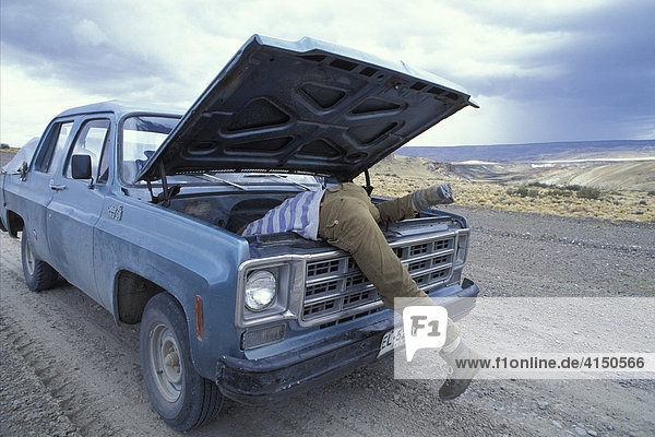 Mann versucht einen Chevrolet DC10 pickup auf der Panamericana in der Pampas zu reparieren Süd-west Argentinien MR