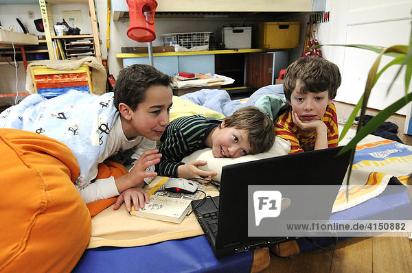 Drei Jungen spielen Computer