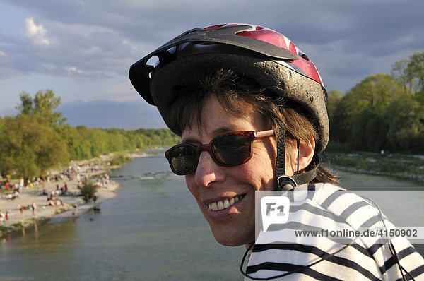 Woman wearing sunglasses and bicycle helmet at the Flaucher  an offshoot of the Isar River  Munich  Upper Bavaria  Germany  Europe