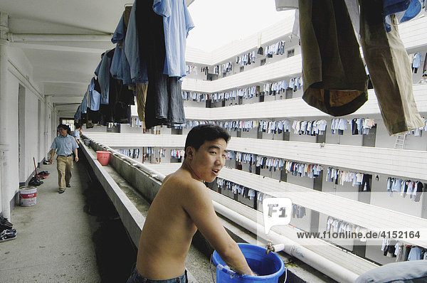Worker in a factory flat washing himself in the morning  China
