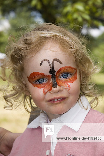 Little girl with a make up butterfly on her face