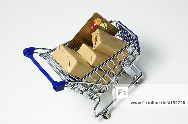 Einkaufen im Internet  ein Einkaufswagen mit Paketen ist gefüllt mit Paketen und einer Kreditkarte