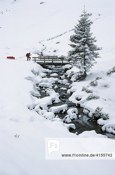 Schneeschuhgeherin zieht eine Pulka im Sellrain Österreich