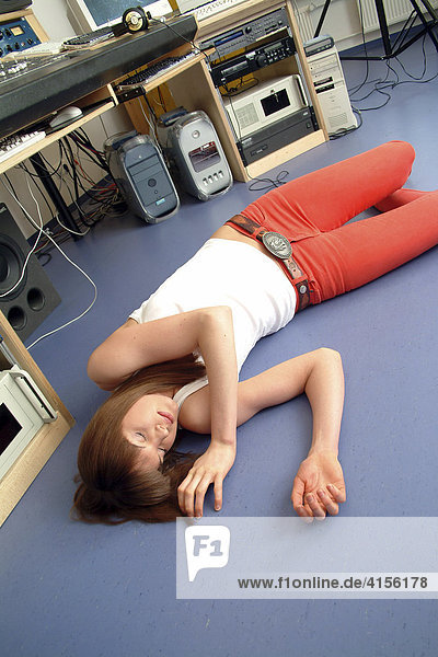 Junge Frau liegt ohnmächtig auf dem Boden eines Tonstudios