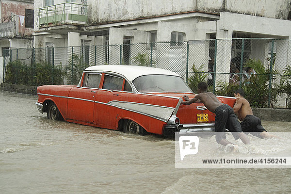 Ein Regenguss überflutet die Strassen von Havanna. Amerikanischer Oldtimer in Havanna Kuba