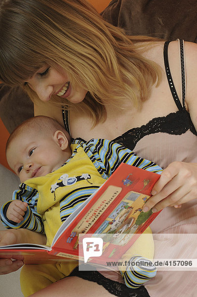 Mutter und Baby sehen sich Bildwörterbuch an