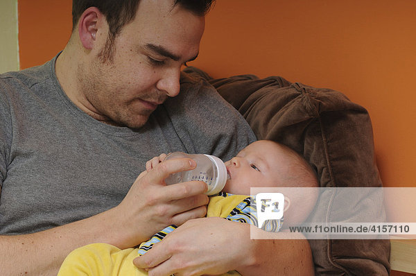 Father feeding baby with bottle