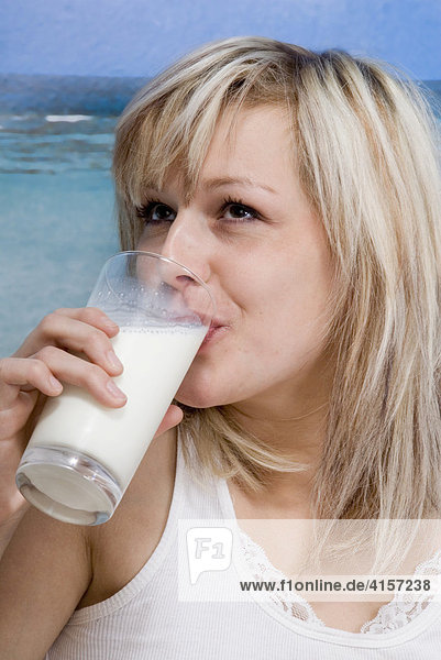 Blonde Frau in Unterwäsche trinkt ein Glas Milch  Fototapete