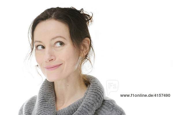Frau mit grauem Pullover lächelt und schaut verschmitzt (Freisteller)