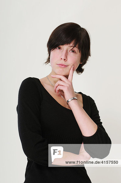 Schwarzhaarige Frau denkt nach
