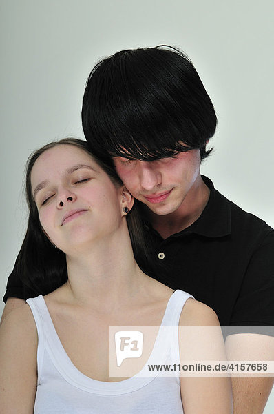 Junges  schwarzhaariges Paar umarmt sich mit geschlossenen Augen  Portrait