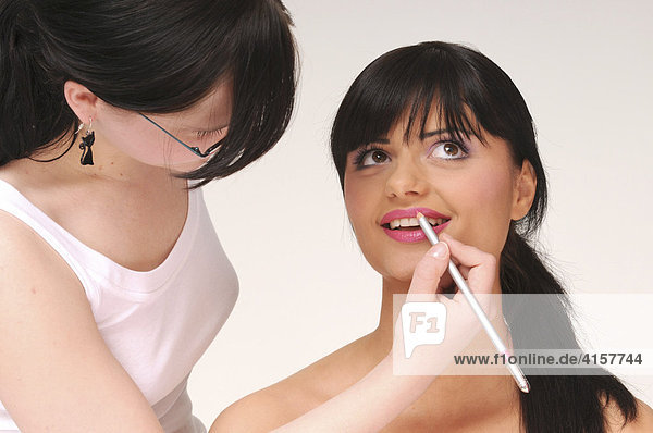 Pretty black-haired woman with a fringe  being made-up  make-up  beauty  pink  lipstick