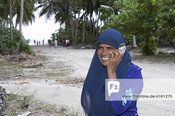 Frau mit Kopftuch und Handy  Malediven