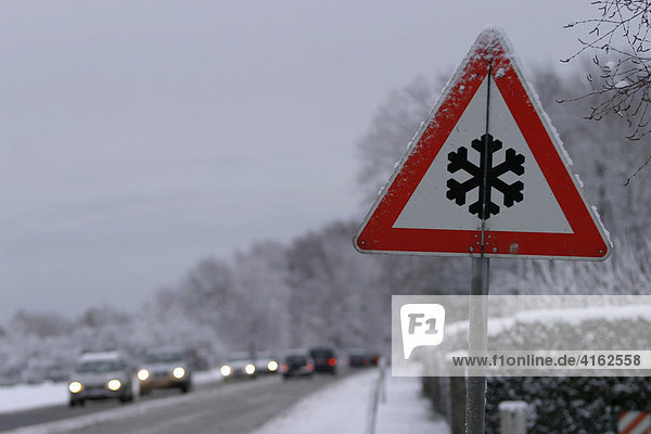 Achtung Schnee  Verkehrsschild. Verschneite Landstrasse im Winter  Deutschland.