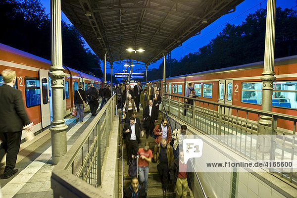 Passengers getting off train at a platform at dusk  Hesse  Germany