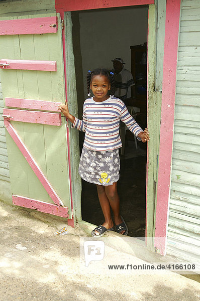 Young girl circa six years old standing in the doorway of a modest home in Santo Domingo  Dominican Republic  Caribbean  Americas