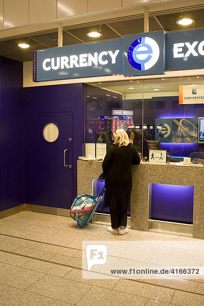 Young woman changing money at a currency exchange counter  Frankfurt International Airport  Hesse  Germany