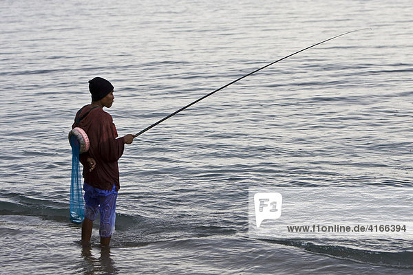 Fischer angelt bei Regen am Ufer  Insel Lombok  Kleine Sunda-Inseln  Indonesien