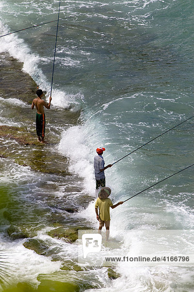 Fishermen standing in the surf  fishing  Lombok Island  Lesser Sunda Islands  Indonesia  Asia