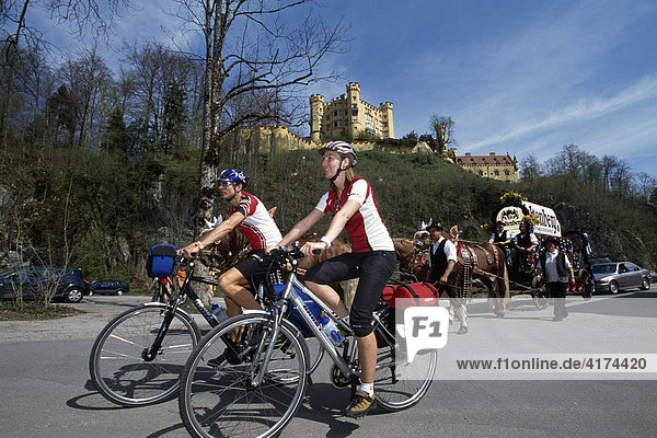 Two bikers in front of Hohenschwangau castle  Fuessen  Allgaeu  Bayern  Deutschland