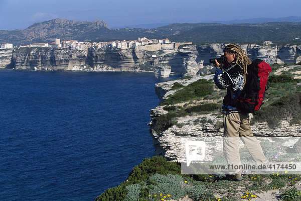 Hiker takes a picture  steep coast of Bonifacio  Corsica  France