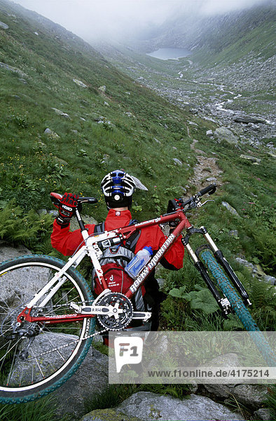 Mountainbiker carries his bike  Transalp  Kalser Tauern  Hohe Tauern  Alps  Austria