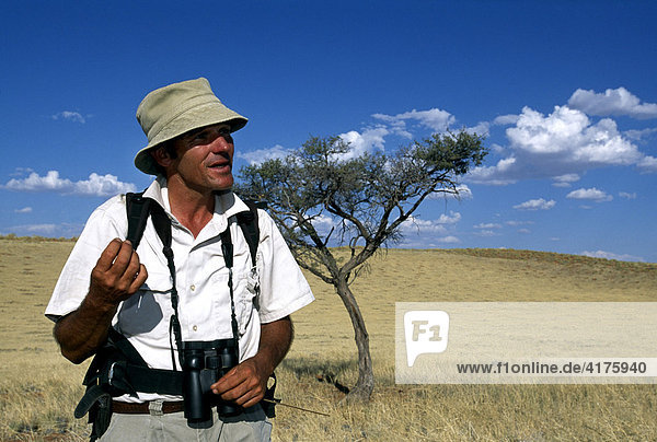Man holding binoculars  Tok Tokkie Trail  NamibRand Nature Reserve  Namibia  Africa