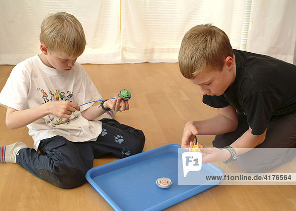 Jungen spielen mit beyblade
