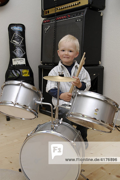 Little boy plays drums