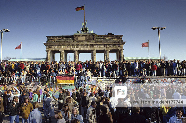 Fall der Berliner Mauer: Menschen aus Ost- und West-Berlin sind auf die Mauer am Brandenburger Tor geklettert. Berlin  Deutschland