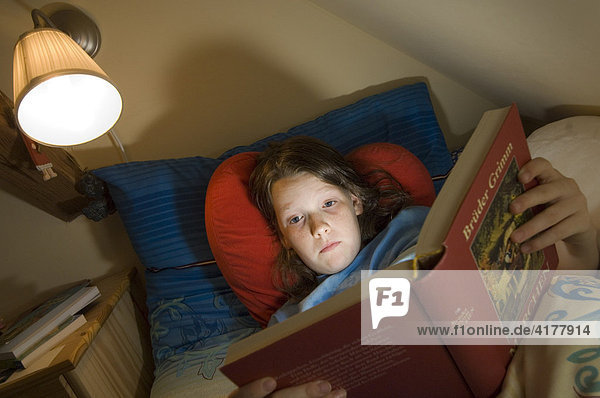 Mädchen liest im Bett