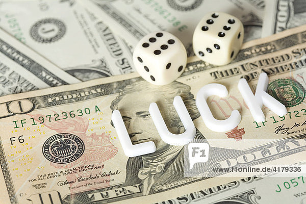 Würfel auf Dollarscheinen mit Luck (Glück) Schriftzug