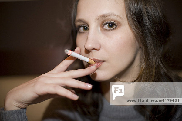 Junge Frau raucht eine Zigarette