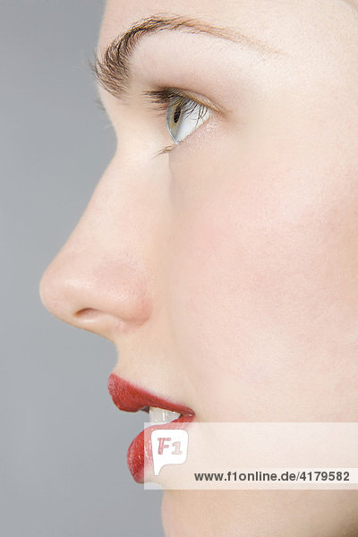 Close-up of young woman's face  profile  red lips mouth