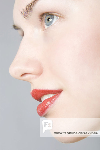 Nahaufnahme des Gesichts einer jungen Frau mit roten Lippen im Profil mund