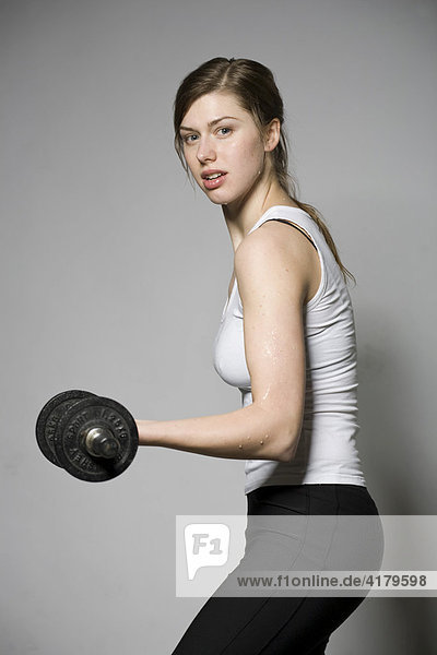 Young woman working out with weights  barbells