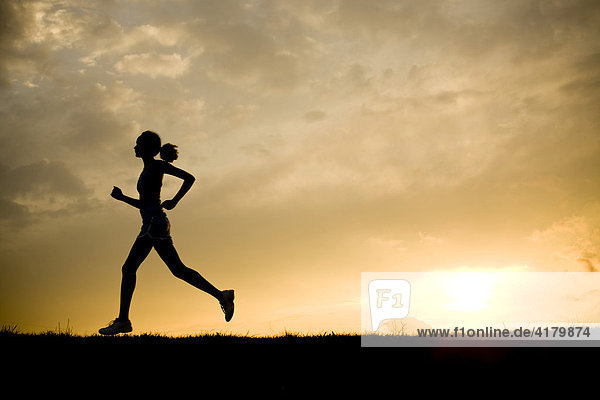 Silhouette of a woman jogging at sunset