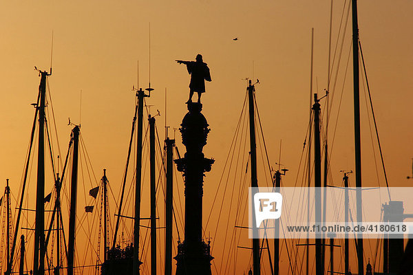 Silhouette des Kolumbus-Denkmal bei Sonnenuntergang zwischen den Masten des Yachthafens Barcelona  Spanien