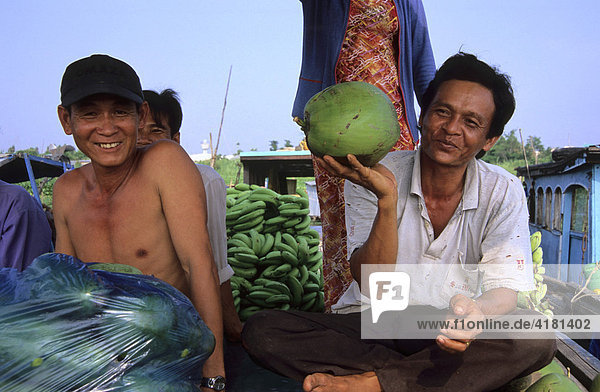 Two men  one holding a coconut  at the floating market in Long Xuyen  Mekong Delta  Vietnam  Asia