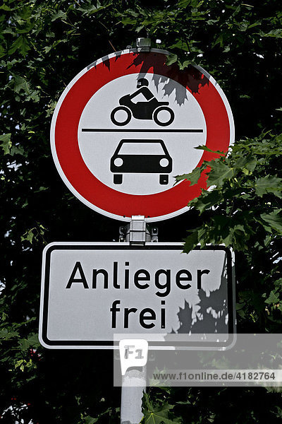 Traffic sign partially obscured by tree