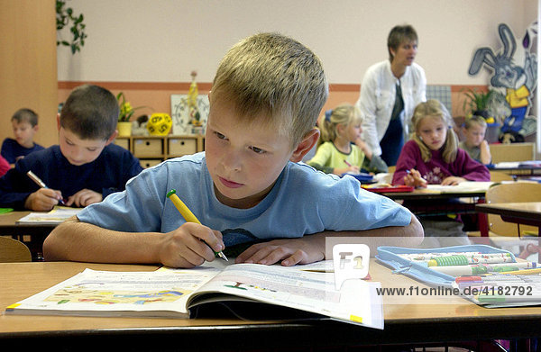 Grundschulschueler beim konzentrierten Schreiben im Klassenzimmer