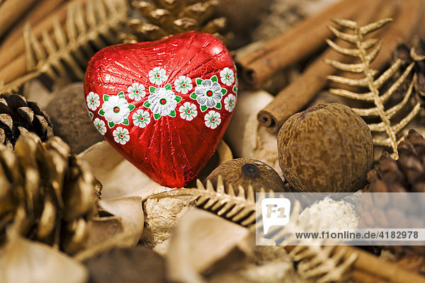 Christmas decoration nuts spices fir cones and red heart of chocolate