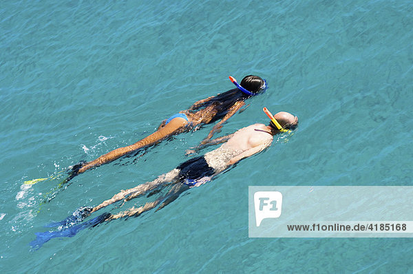 Schwimmendes Paar  ein Mann und eine Frau schwimmen mit Schnorchel und Flossen im türkisblauen Wasser des Mittelmeers  Griechenland.