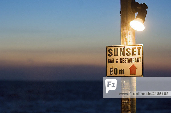 Sonnenuntergang in achtzig Metern. Hinweisschild auf eine Bar am Ufer von der aus man den Sonnenuntergang beobachten kann Griechenland