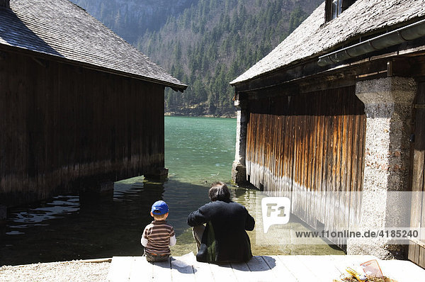 Father and son  near two boathouses in Koenigssee  Bavaria  Germany