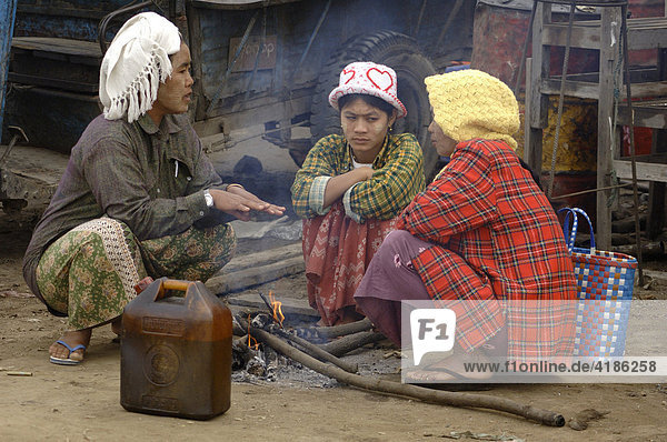 Women sitting at a fire  Myanmar  Burma