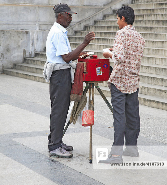 Professional photographer with historic plate camera in front of El Capitolo  national capitol building in Havana  Cuba  Caribbean