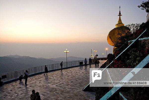 Goldener Felsen mit Stupa und Vorplatz beim Sonnenuntergang  Kyaikhtiyo  Myanmar (Burma)  Südostasien