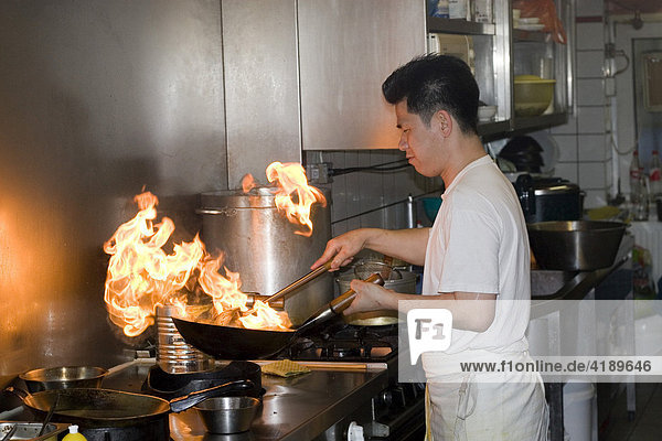 Vietnamesischer Koch beim arbeiten mit dem Wok