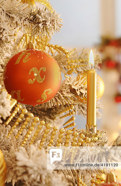 Geschmückter Weihnachtsbaum mit brennender Kerze